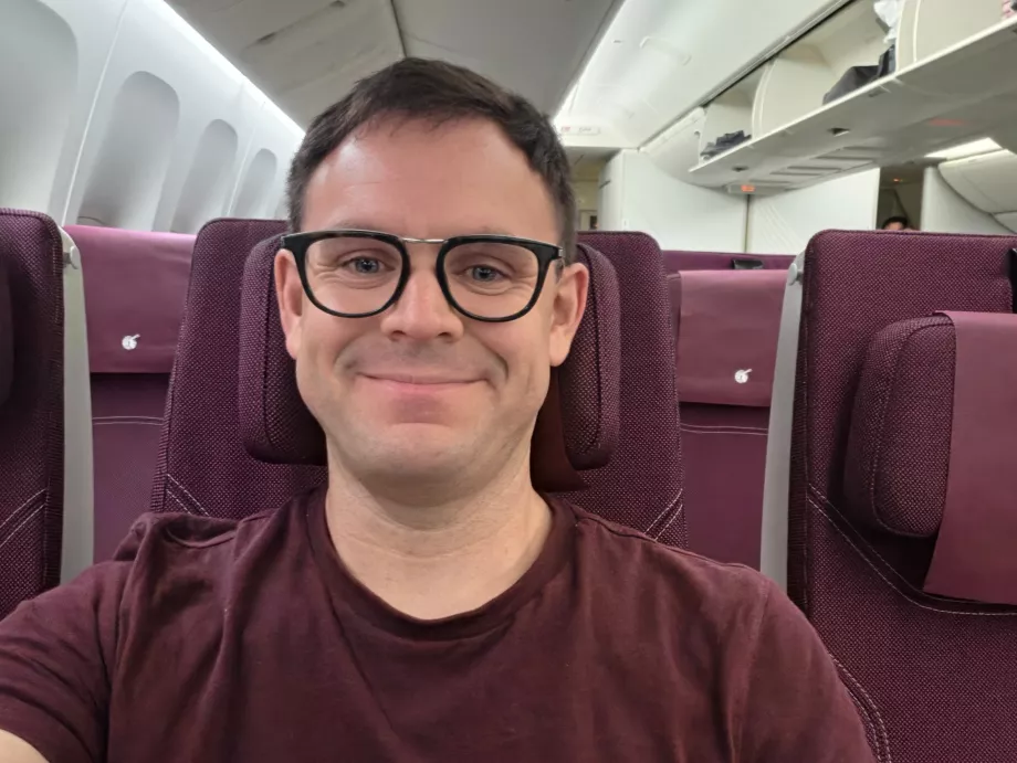 Я в літаку Qatar Airways (моя футболка ідеально пасує до колірної гами салону!)